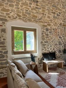 圣茹尔德马朗讷Le Ranch Kabahina Golf的带沙发和石墙的客厅