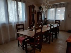 圣雷米·莱谢夫勒斯chambre d'hôte "Chambre dans une maison pleine de vie"的一间带木桌和椅子的用餐室