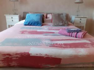 圣雷米·莱谢夫勒斯chambre d'hôte "Chambre dans une maison pleine de vie"的床上有色彩缤纷的毯子和枕头