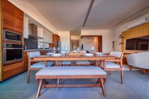 巴亚尔塔港Luxurious Penthouse in Puerto Vallarta的一间带木桌和椅子的用餐室