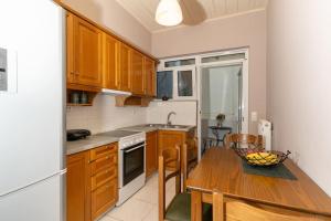 扎金索斯镇Fivos apartment的厨房配有木桌,上面放着一碗水果