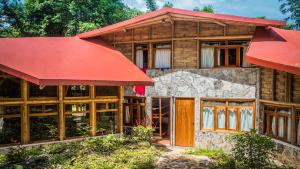 库埃察兰德尔普罗格雷索Cabañas Tosepan Kali的一间红色屋顶的木屋