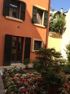 维罗纳隐藏的角落公寓的橙色的建筑,有黑色百叶窗和鲜花
