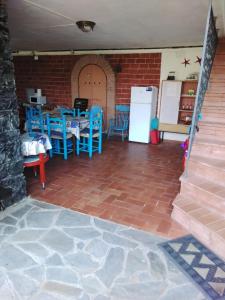 博纳索拉VILLA MIMOSA Splendida Vista Mare的客房配有桌子、蓝色椅子和冰箱。