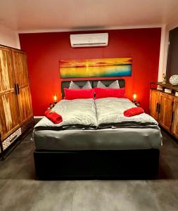 勒沃库森Hafen Perle - Übernachtungen auf dem Wasser- Romantik & Wellness auf dem Rhein -的一间卧室设有一张红色墙壁的大床