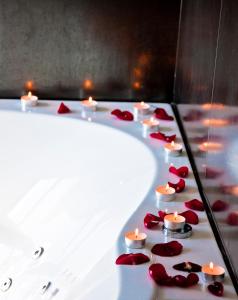 Sasnava格力租罗拉抬酒店的红玫瑰浴缸里的一排蜡烛