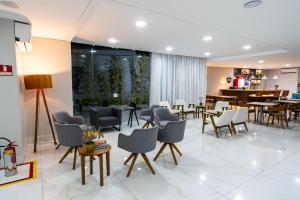 福塔莱萨Stop Way Hotel Fortaleza的一个带桌椅的大堂和一间餐厅
