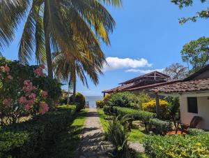 里瓦斯Hotel Playa Santa Martha的一条穿过花园的小路,花园的背景是大海