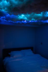 费城Nimbus Cloud King Suite W/ Great Access to City的蓝色的房间,床上有云彩绘的天花板