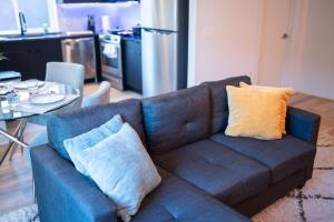 费城Nimbus Cloud King Suite W/ Great Access to City的客厅里配有带两个枕头的蓝色沙发