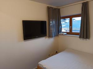 Pinsdorf1 Zimmer Appartement nahe Gmunden Top2的卧室配有壁挂式平面电视。