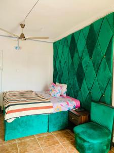 莱基New Travellers Lodge Sangotedo Lagos的一间卧室配有一张床和一把椅子