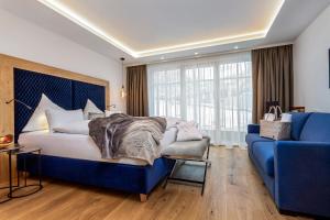 萨尔巴赫诺伊豪斯酒店的一间卧室配有蓝色的床和蓝色的沙发