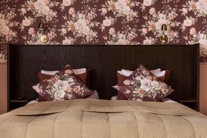 JonseredGibsons Hotell的一间卧室配有一张带花卉壁纸的大床
