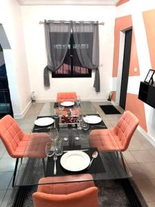 瓦加杜古Résidence meublée的一间带桌子和橙色椅子的用餐室