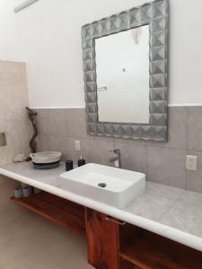 巴卡拉尔Camino del Alma Apartments的浴室设有白色水槽和镜子