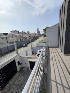 皮萨拉斯Sobrado com piscina, banheira e garagem coberta.的和一座带车的建筑的阳台