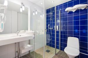 坦佩雷坦佩雷假日酒店 - 中央车站的蓝色瓷砖浴室设有卫生间和水槽