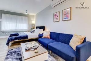 孟菲斯The Moose #9 - Brand New Luxe Modern loft with Free Parking, King Bed & Fast WiFi的客厅配有蓝色的沙发和床。