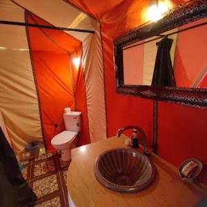 梅尔祖卡Sahara Luxurious Camp的帐篷内带水槽和卫生间的浴室