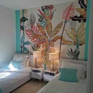 戛纳Blue Dream Cannes Guest House的一间卧室设有两张床和壁画墙