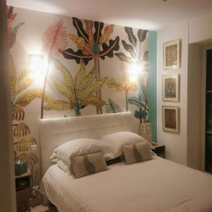 戛纳Blue Dream Cannes Guest House的卧室配有白色的床铺,墙上挂着鲜花