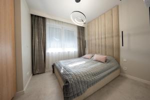 里沃Apartament z Tarasem Morska 6 Rewal 50m do morza的一间卧室配有带粉红色枕头的床。