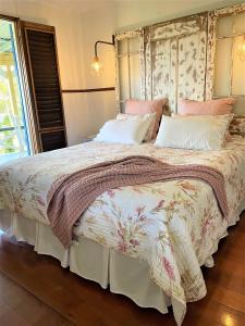 Black MountainNoosa Hinterland Escape的一间卧室配有一张大床,铺有粉色和白色的床单。