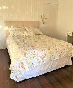 Black MountainNoosa Hinterland Escape的一间卧室配有一张带花卉床罩的大床