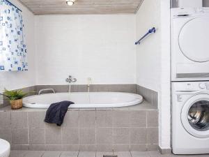 海默特6 person holiday home in Hemmet的带浴缸和洗衣机的浴室。