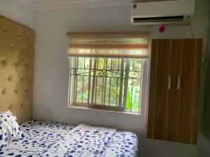 莱基New Travellers Lodge Sangotedo Lagos的一间卧室设有一张床和一个窗口