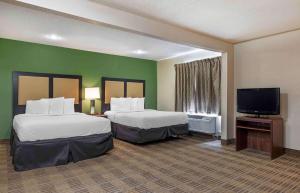 夏洛特Extended Stay America Select Suites - Charlotte - Tyvola Rd - Executive Park的酒店客房设有两张床和一台平面电视。