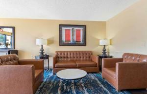 塔尔萨美国扩展酒店 - 塔尔萨 - 中城的客厅配有棕色皮沙发和桌子