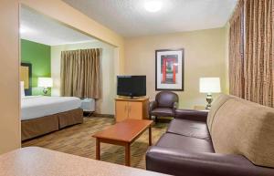 莫米美国长住酒店 - 托莱多 - 莫米的酒店客房配有床、沙发和电视。