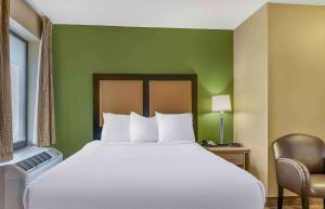 安娜堡Extended Stay America Select Suites - Detroit - Ann Arbor - University South的绿色墙壁间的一张床位