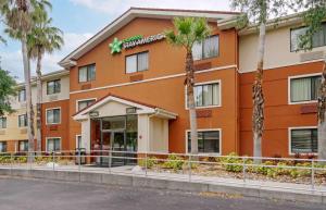 坦帕Extended Stay America Select Suites Tampa Airport Memorial Hwy的一座楼前有棕榈树的酒店