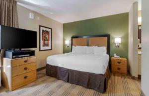 亚特兰大Extended Stay America Select Suites - Atlanta - Marietta - Wildwood的一间卧室配有一张床和一台平面电视