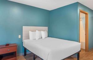 小石城Extended Stay America Select Suites - Little Rock - Southwest的一间卧室配有一张蓝色墙壁的床