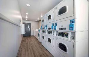 桑福德Extended Stay America Select Suites - Orlando - Sanford - Airport的洗衣房配有白色洗衣机和烘干机