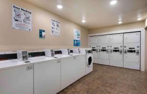 小石城Extended Stay America Select Suites - Little Rock - Southwest的洗衣房配有白色洗衣机和烘干机