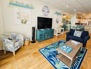 彭萨科拉海滩Pensacola Beach Front Emerald Waters的客厅配有两把椅子和电视