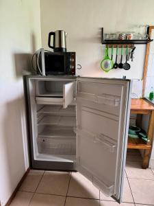 安加罗阿Cabañas Tangaroa y Hamea的厨房设有一台开放式冰箱,配有微波炉