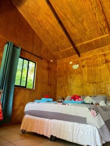 安加罗阿Cabañas Tangaroa y Hamea的卧室配有木墙内的一张床