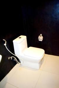卡图纳耶克Airport Heritage Hotel的浴室设有白色的卫生间和黑色的墙壁