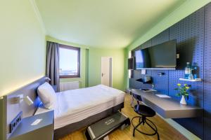 雷姆沙伊德米克雷姆沙伊德酒店的一间卧室配有一张床、一张书桌和一台电视。