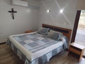 AngolParcela Zurich, casa 1的卧室配有一张床,墙上有十字架