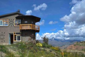 拉巴斯Andean Lodge in La Paz的山顶上带阳台的房子