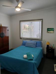 福斯特Our Retreat的一间卧室设有蓝色的床和窗户。