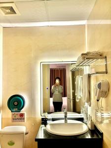 河内Keypad Hotel - 87 Nguyễn Khang的照着浴室镜子的女人