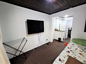 佩德拉德瓜德拉巴Lindo Flat2 a 300 mts da praia posto 12 Recreio的客厅的墙上配有平面电视。